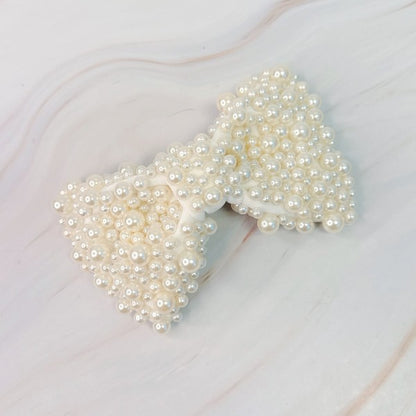 White pearl bow hair clip with elegant design for bridal hairstyles