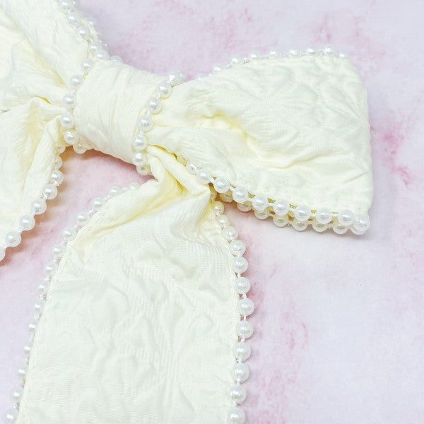 White pearl embellished bow barrette with elegant embossed fabric