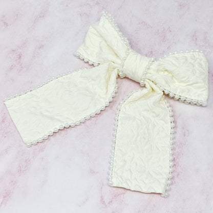 White pearl embellished bow barrette with elegant embossed fabric