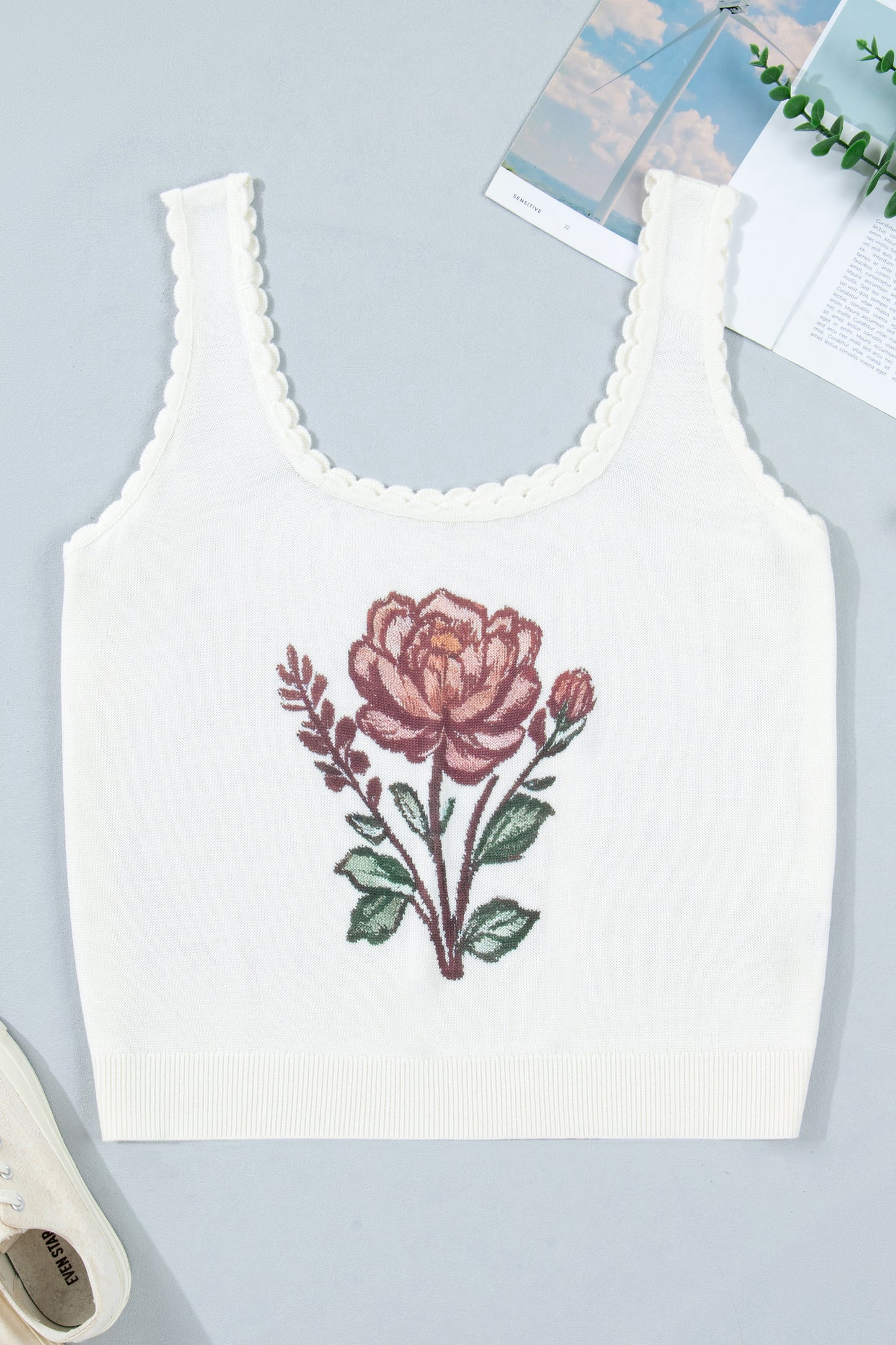 White tank top with pink floral design on a light blue background